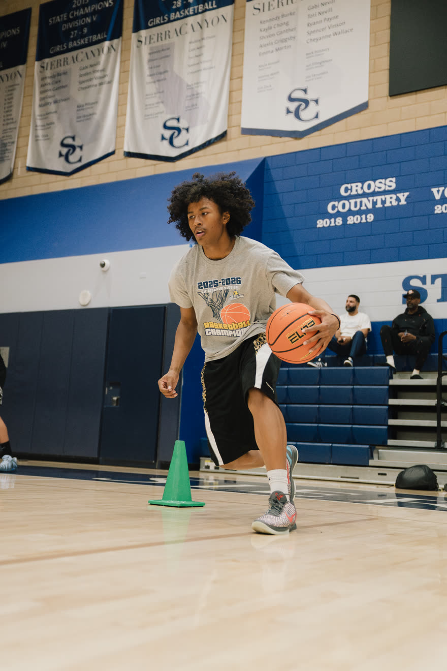 A CIBA athlete driving past a cone during a one-on-one ball-handling drill.